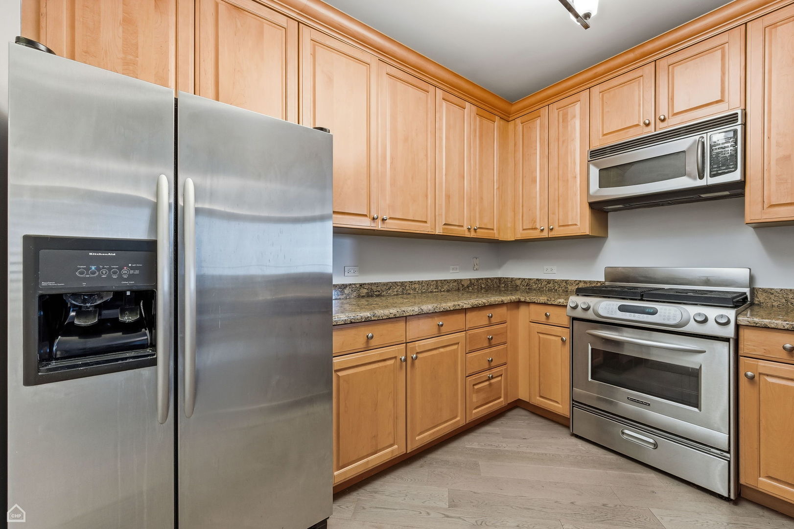 420 East Waterside Drive, Unit 1502 Chicago, IL 60601 - Photo 5 of 11 a kitchen with stainless steel appliances granite countertop a refrigerator and a stove top oven