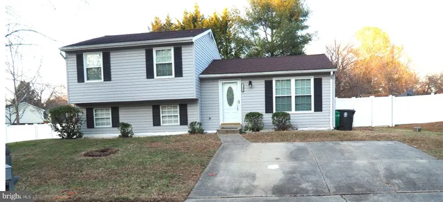 a front view of a house with a yard and potted plants