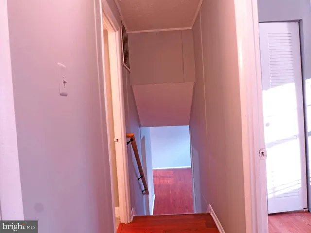 a view of hallway with a fireplace and wooden floor