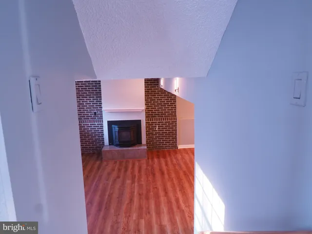 a view of empty room with wooden floor and fireplace