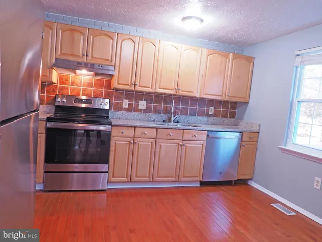 a kitchen with granite countertop a stove and a sink