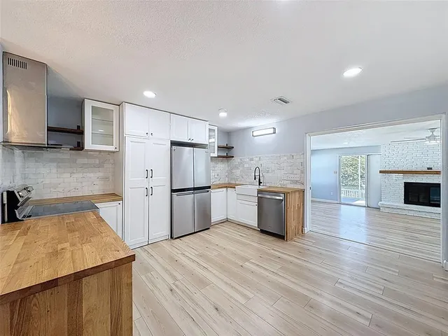 a kitchen with stainless steel appliances a refrigerator sink and microwave