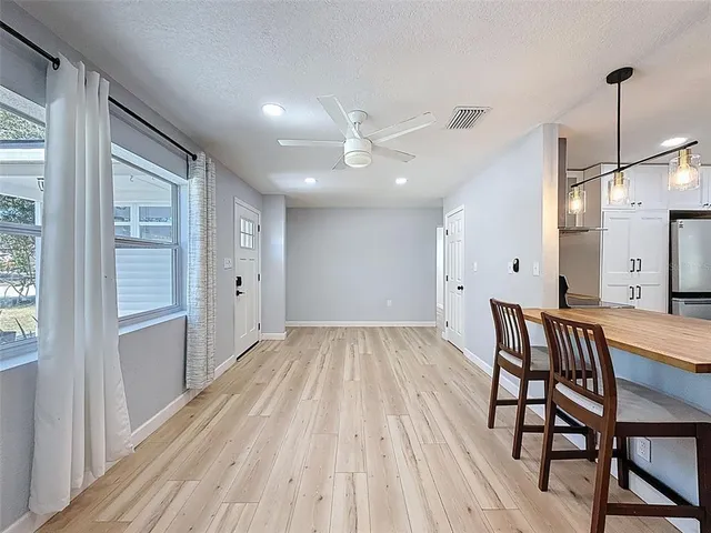 a view of a room with wooden floor and a hallway