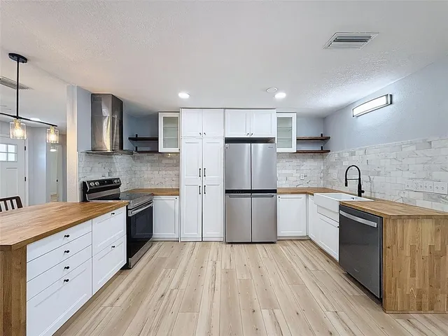 a kitchen with a sink a refrigerator and a stove top oven
