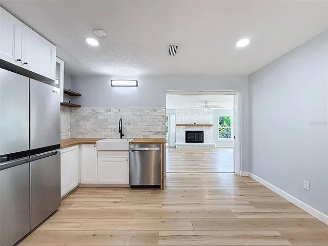 a kitchen with stainless steel appliances granite countertop a refrigerator a stove and a sink