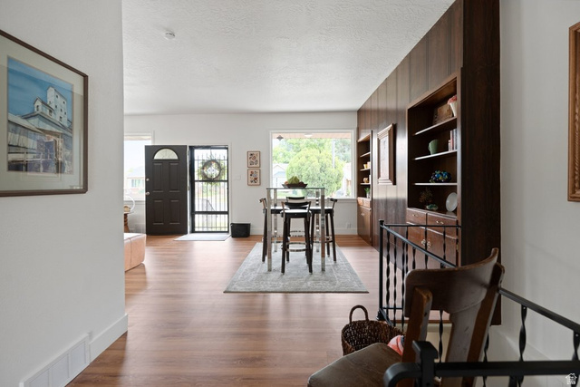 673 East 700 South Springville, UT 84663 - Photo 19 of 43 Wood-finish flooring throughout an open living space featuring a dark wood paneled accent wall with integrated shelving and cabinetry