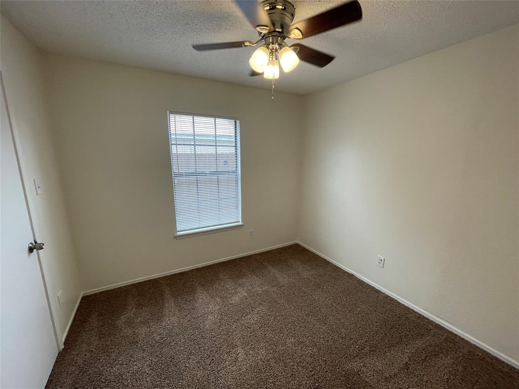 9415 Rutherglen Drive Dallas, TX 75227 - Photo 16 of 18 an empty room with a window and a fan
