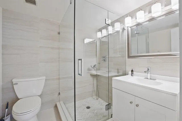 a bathroom with a toilet sink shower and mirror
