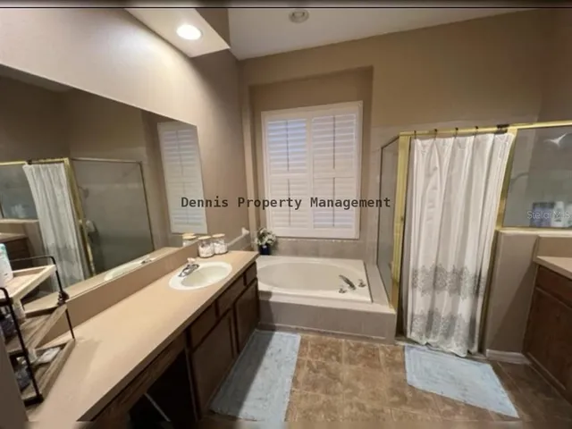 a bathroom with a tub sink and mirror