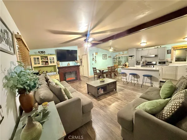 a living room with furniture kitchen view and a fireplace
