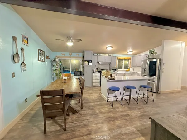 a dining hall with stainless steel appliances kitchen island granite countertop furniture and a kitchen view