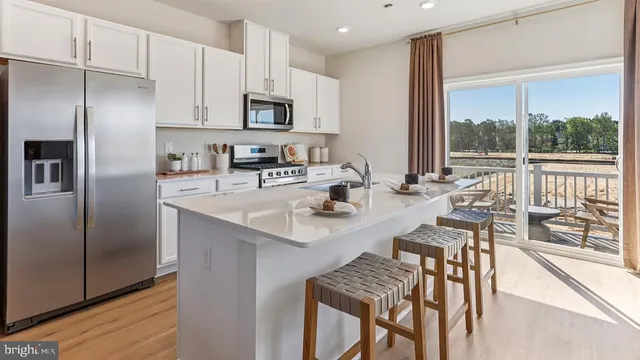 a kitchen with kitchen island a large window appliances and cabinets