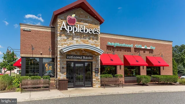 front view of a brick house with a clock on the wall