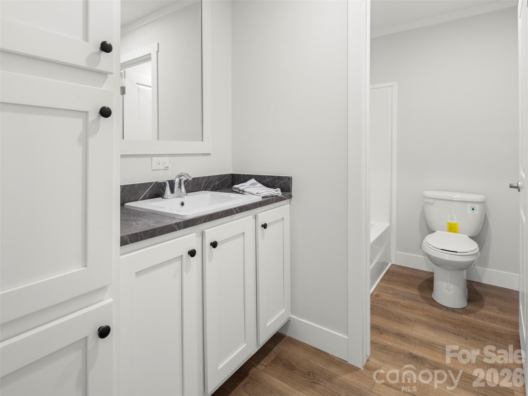 502 Hutch Mountain Road Fletcher, NC 28732 - Photo 23 of 26 a bathroom with a granite countertop toilet a sink and a window