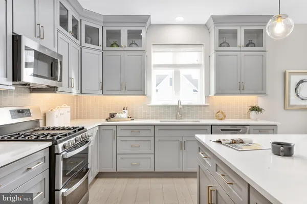 a kitchen with stainless steel appliances a stove a sink and a microwave
