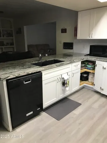 a kitchen with granite countertop a stove a sink and a microwave