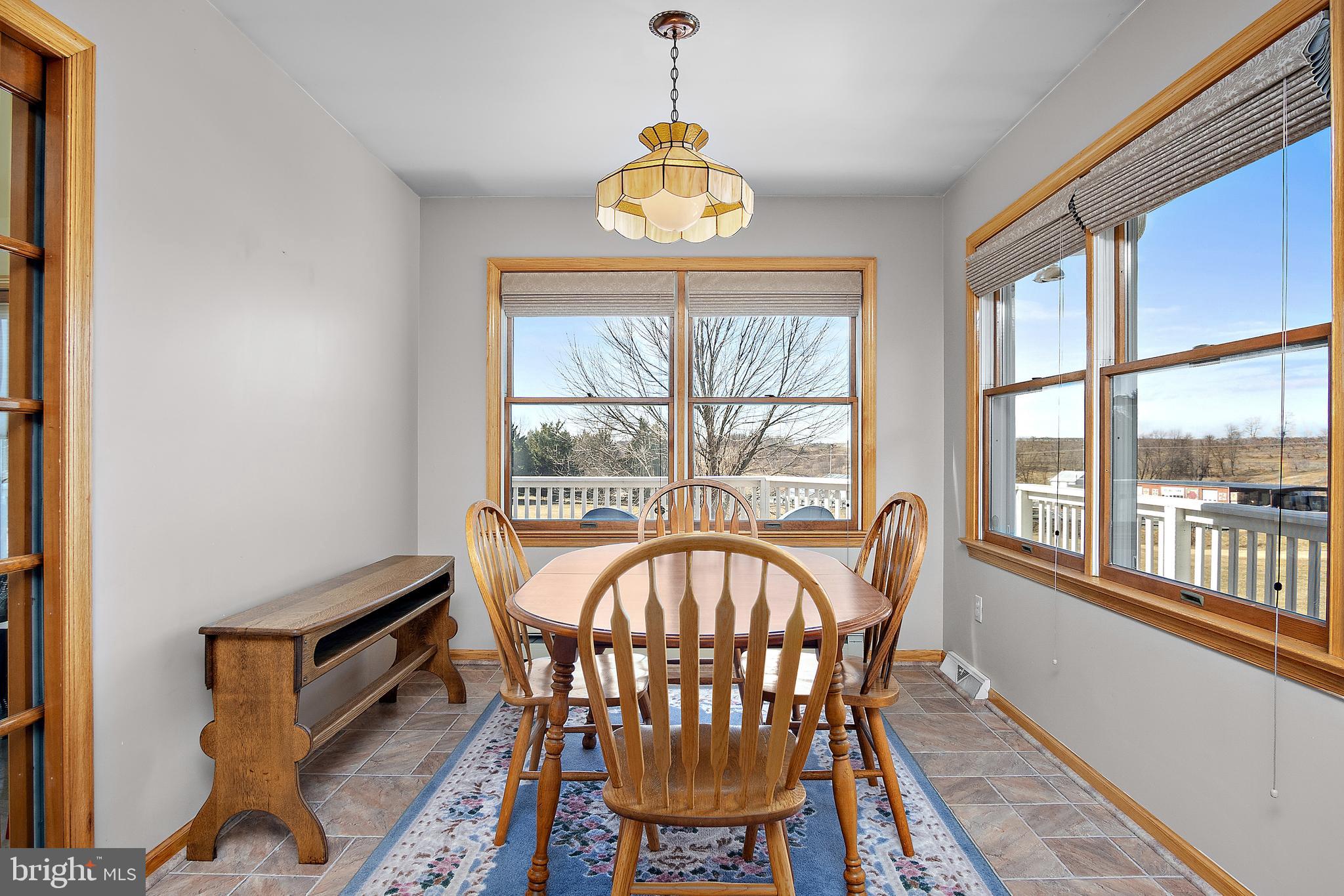 13810 Franks Run Road Smithsburg, MD 21783 - Photo 16 of 72 a view of a dining room with furniture a chandelier and a window