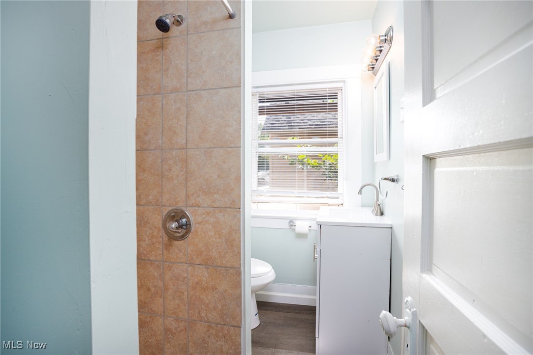 555 Brittain Road Akron, OH 44305 - Photo 15 of 26 Bathroom with tiled shower, vanity, and wood finished floors