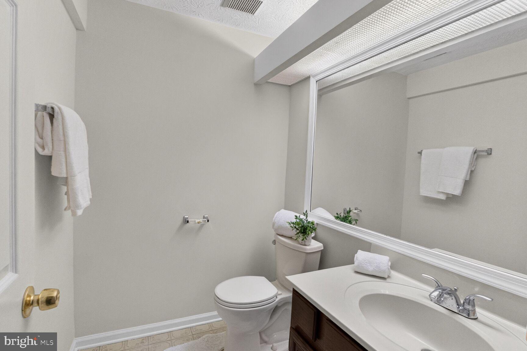 4303 Thistlewood Terrace Burtonsville, MD 20866 - Photo 23 of 26 a bathroom with a granite countertop sink toilet and a mirror