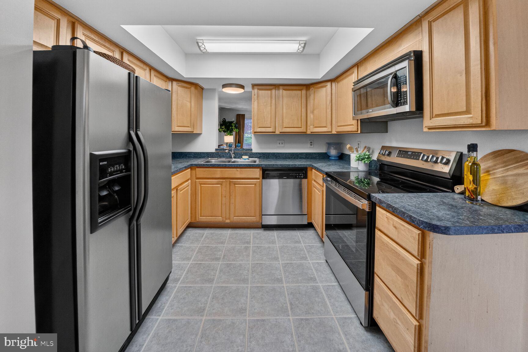 4303 Thistlewood Terrace Burtonsville, MD 20866 - Photo 7 of 26 a kitchen with stainless steel appliances granite countertop a refrigerator a stove and a sink