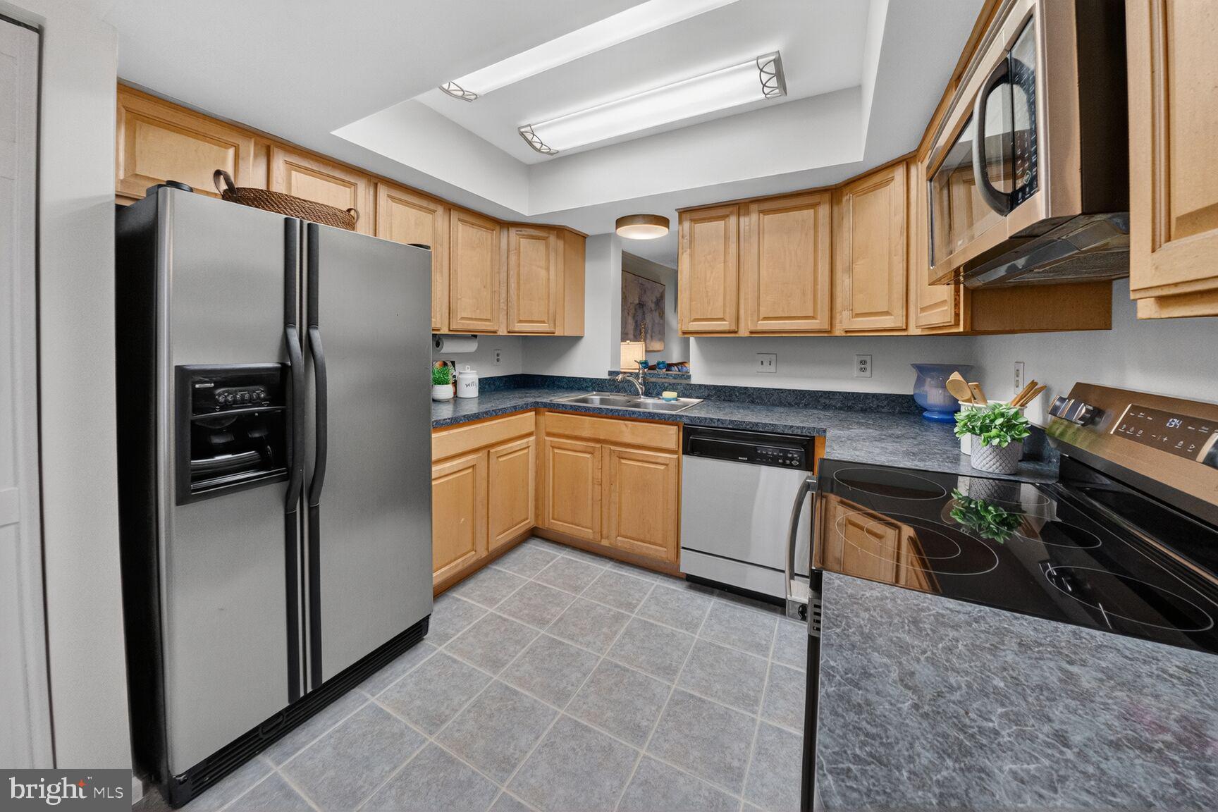 4303 Thistlewood Terrace Burtonsville, MD 20866 - Photo 8 of 26 a kitchen with stainless steel appliances granite countertop a refrigerator a sink a stove and cabinets