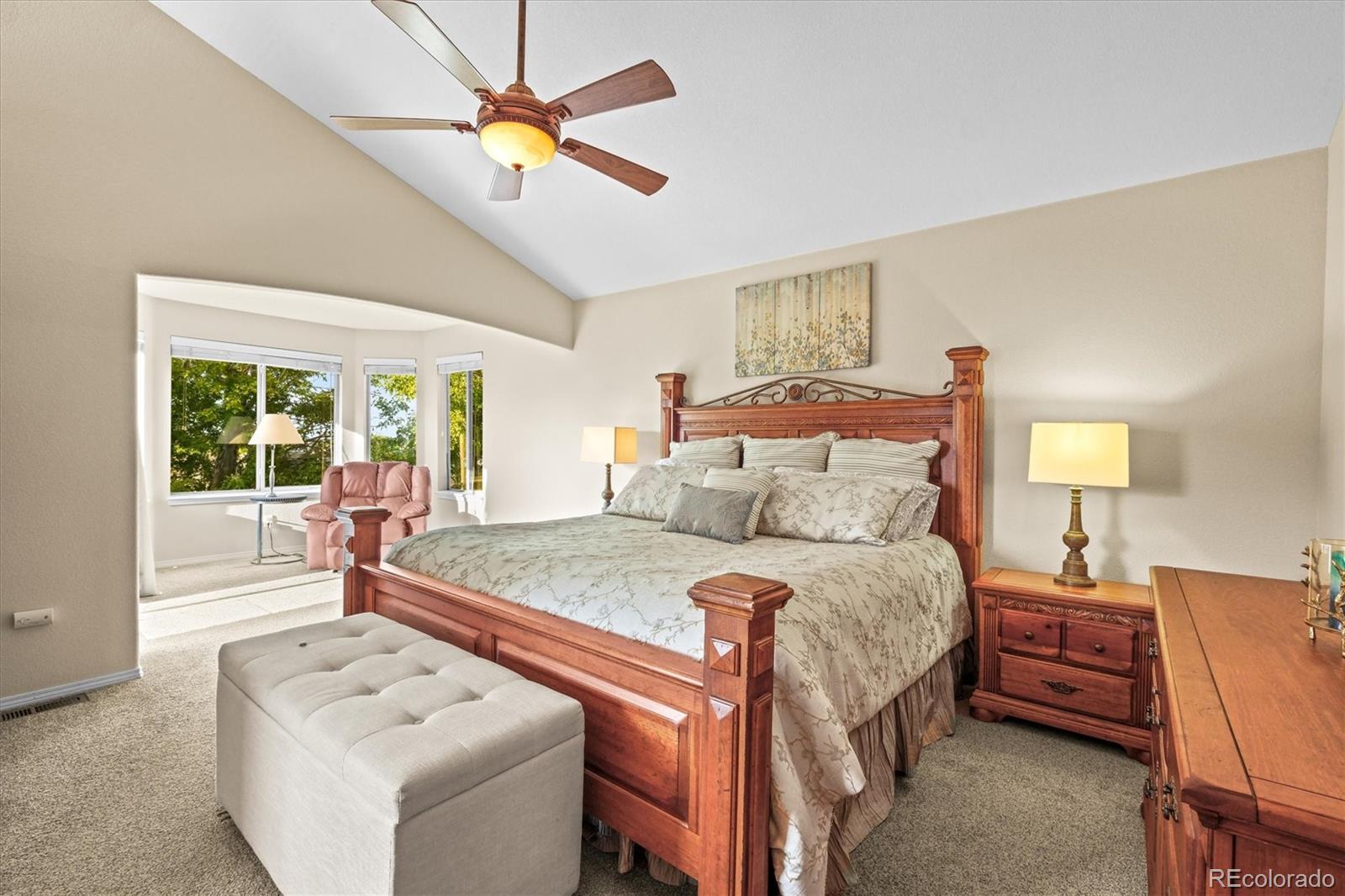 3115 White Oak Lane Highlands Ranch, CO 80129 - Photo 14 of 43 a bedroom with a bed a chandelier and a couch