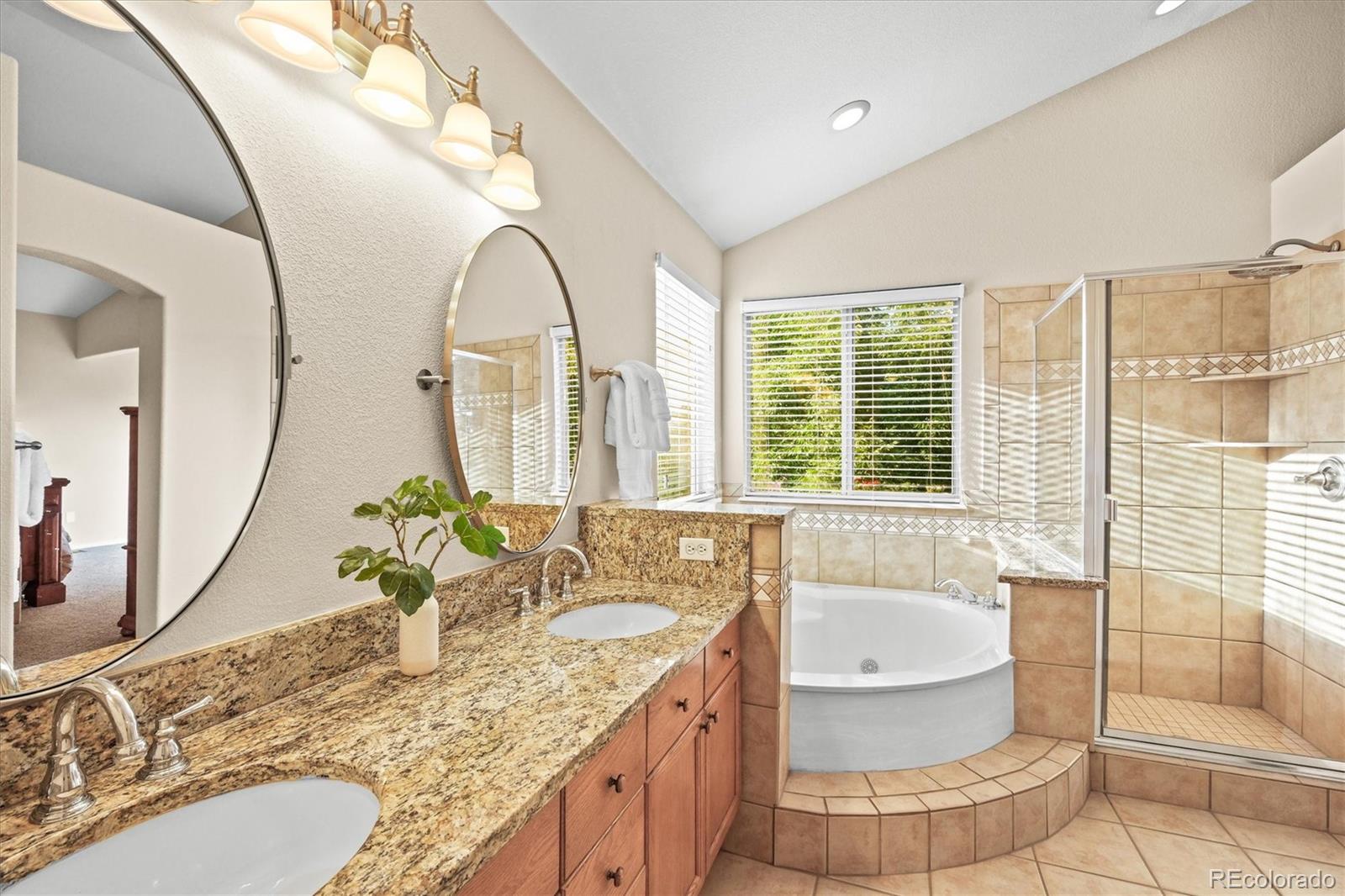 3115 White Oak Lane Highlands Ranch, CO 80129 - Photo 16 of 43 a bathroom with a granite countertop sink mirror and a bathtub