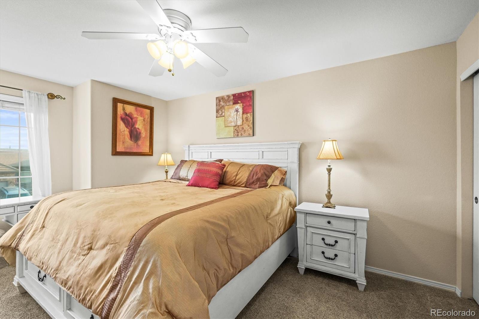 3115 White Oak Lane Highlands Ranch, CO 80129 - Photo 21 of 43 a bedroom with a bed and a chandelier