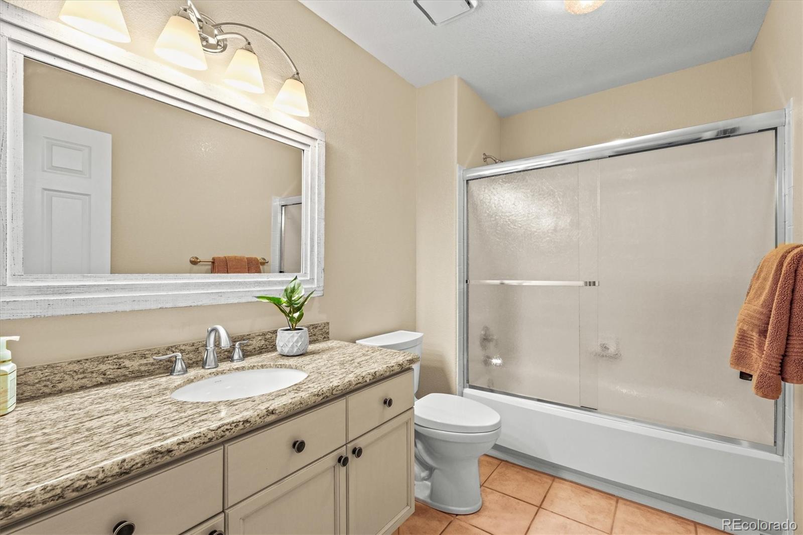 3115 White Oak Lane Highlands Ranch, CO 80129 - Photo 27 of 43 a bathroom with a granite countertop sink toilet and shower