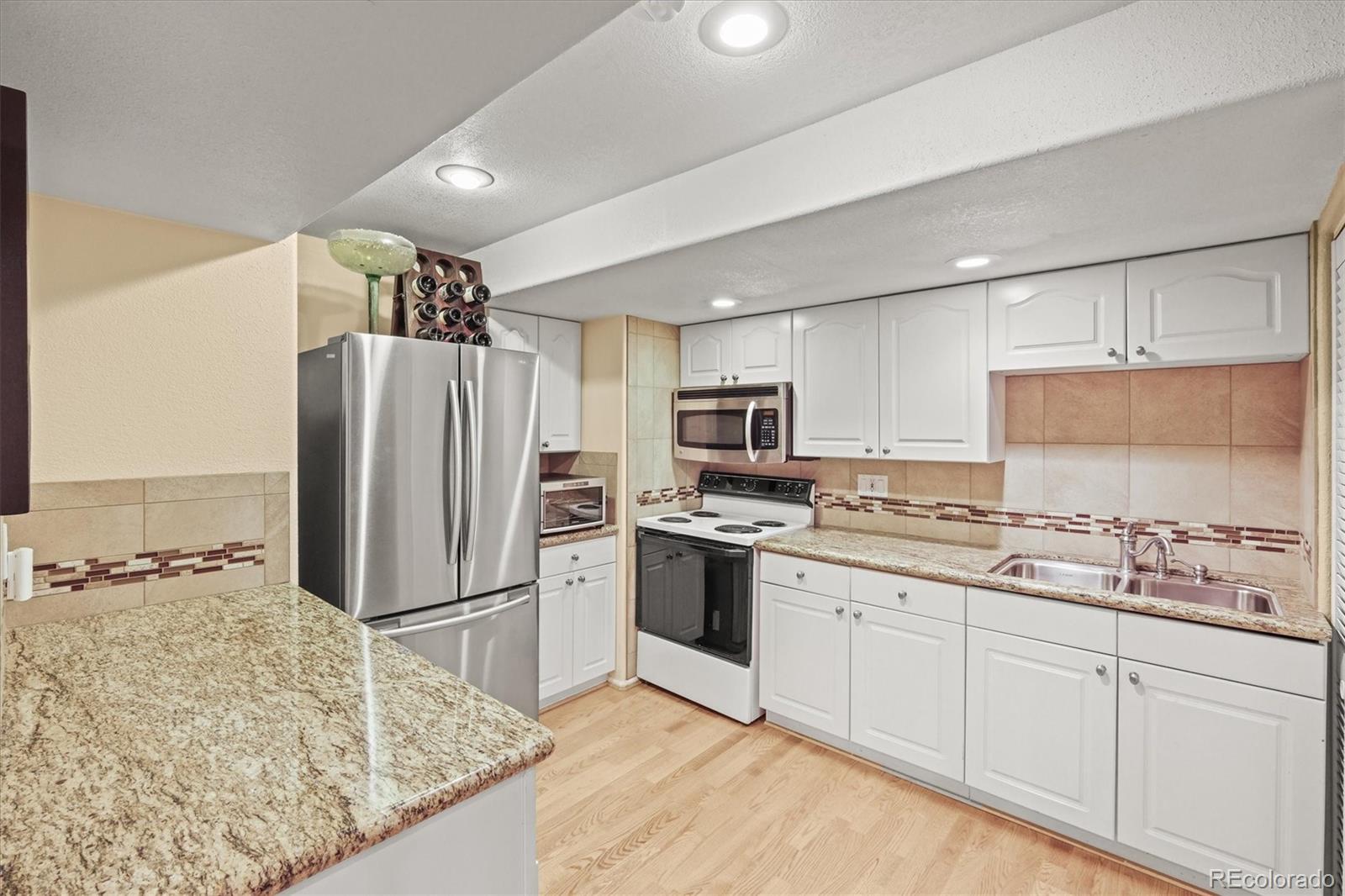 3115 White Oak Lane Highlands Ranch, CO 80129 - Photo 29 of 43 a kitchen with stainless steel appliances granite countertop a refrigerator sink and stove