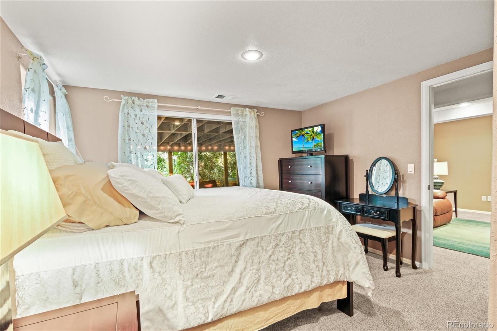 3115 White Oak Lane Highlands Ranch, CO 80129 - Photo 32 of 43 a bedroom with a bed and a dresser with mirror