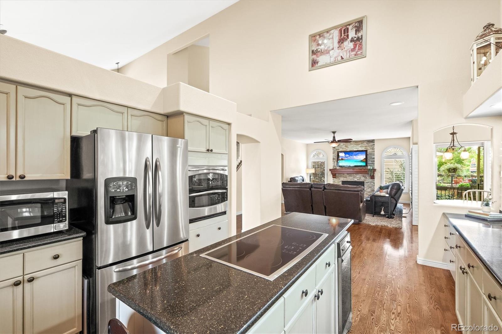 3115 White Oak Lane Highlands Ranch, CO 80129 - Photo 10 of 43 a kitchen with stainless steel appliances granite countertop a refrigerator a stove and a sink with wooden floors