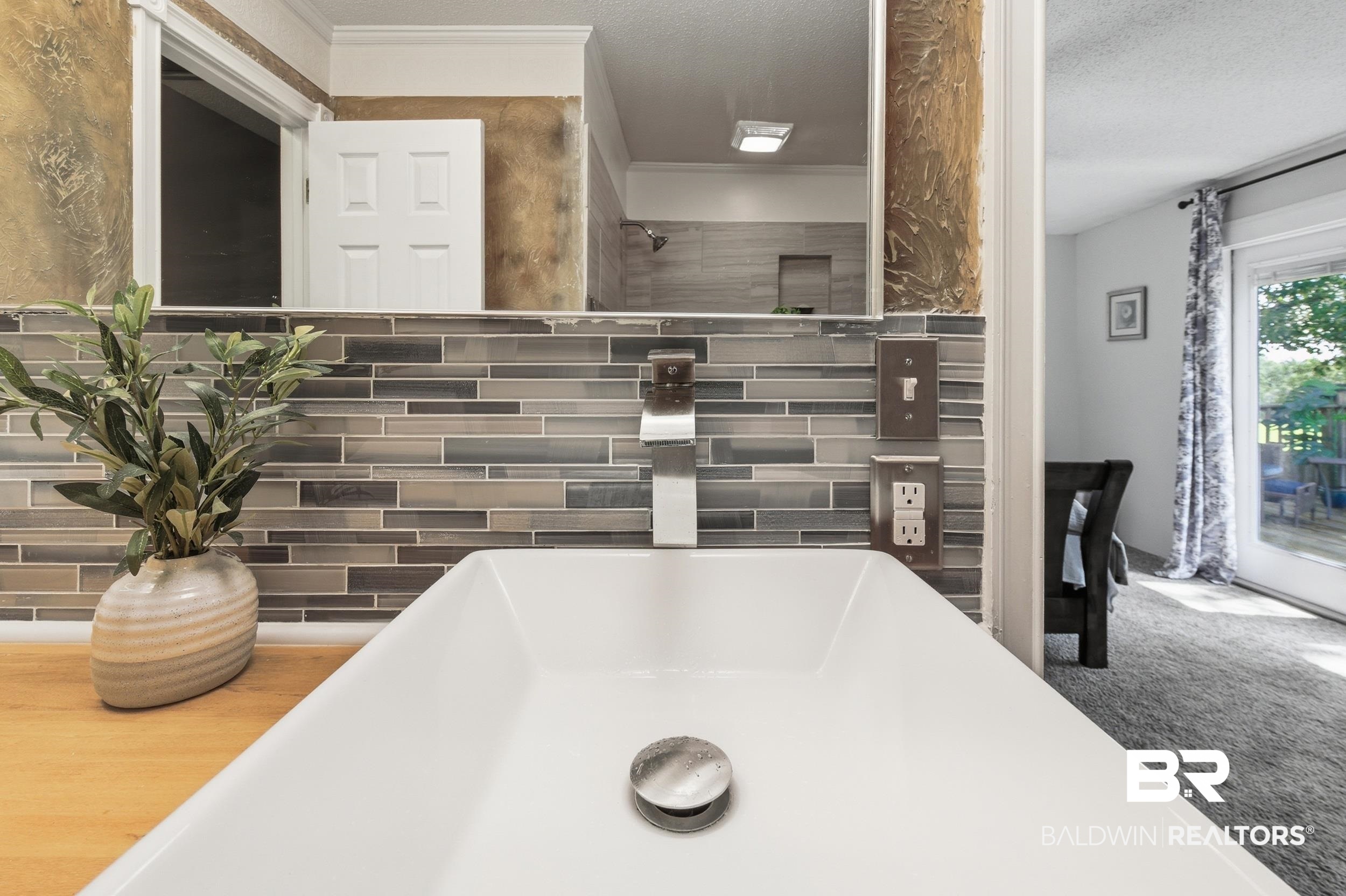 51620 Robert White Road Bay Minette, AL 36507 - Photo 48 of 81 Bathroom featuring a rectangular vessel sink with a chrome wall-mounted faucet, set upon a wood-finish countertop