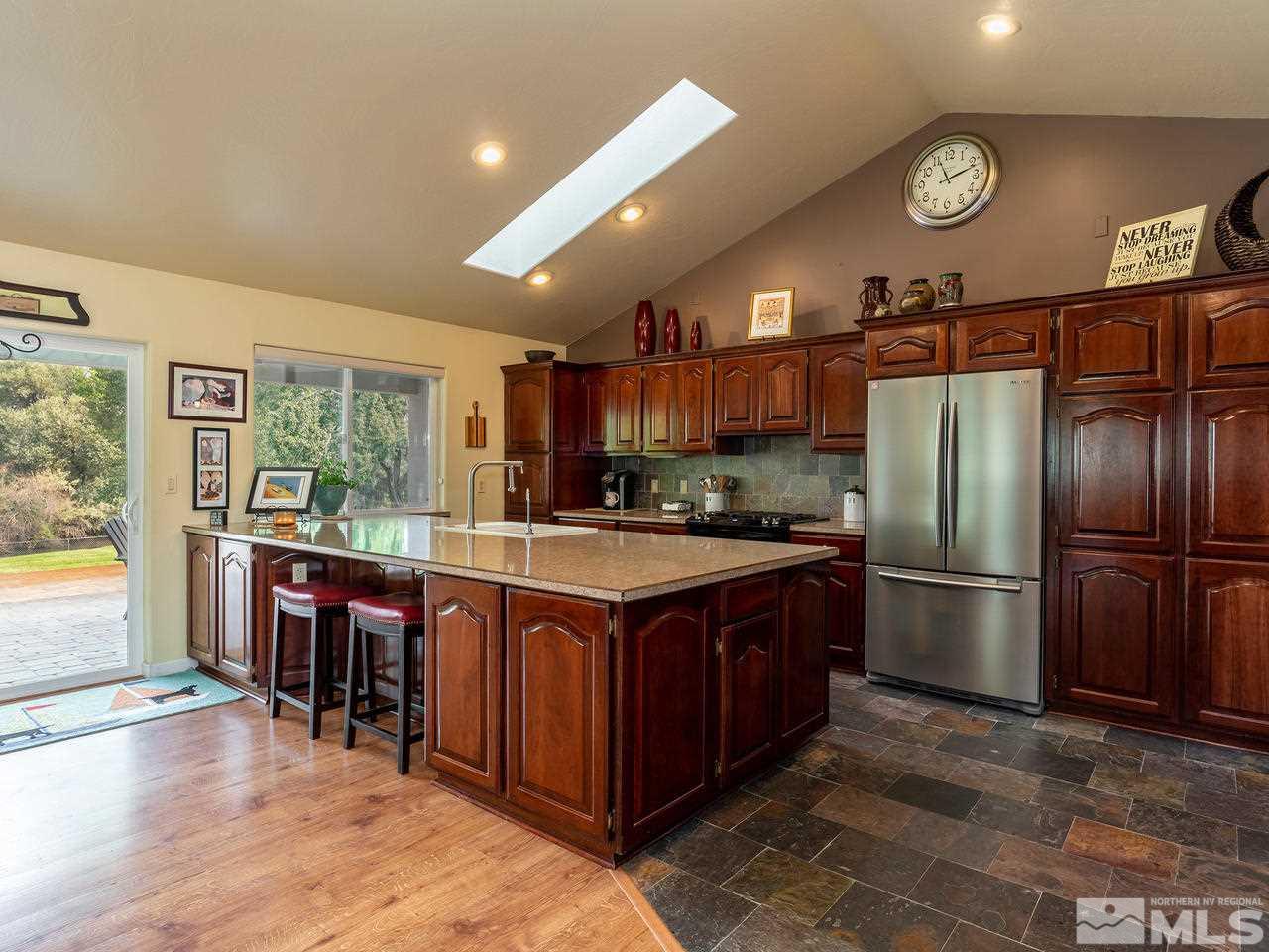 5112 Rivers Edge Drive Fallon, NV 89406 - Photo 7 of 25 a kitchen with stainless steel appliances granite countertop a stove a refrigerator a sink a dining table and chairs with wooden floor