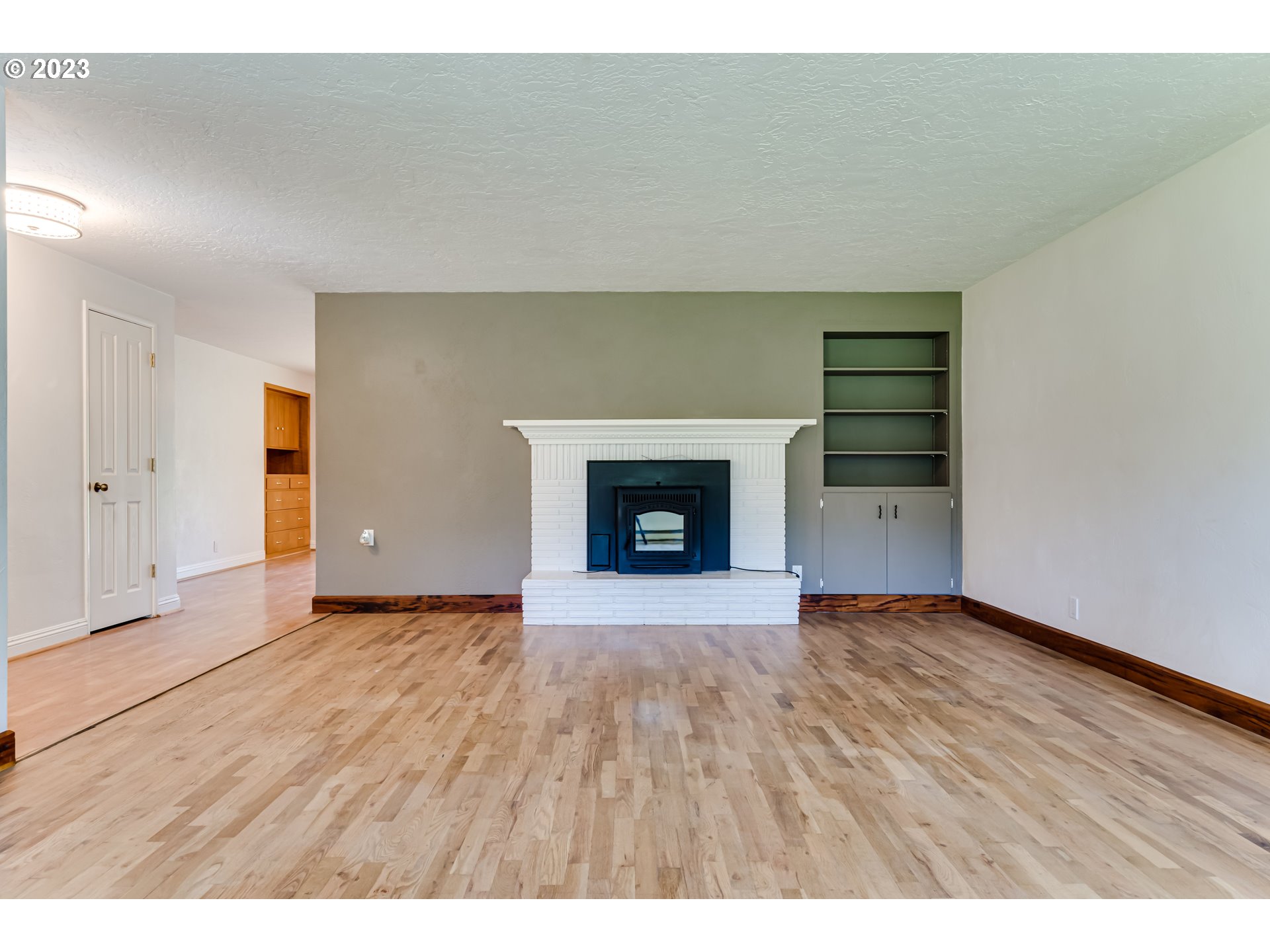 34886 Mathews Road Eugene, OR 97405 - Photo 12 of 48 a view of an empty room with wooden floor fireplace and a window