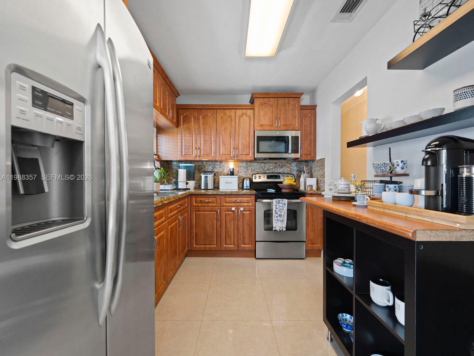 8530 Northwest 179th Street Hialeah, FL 33015 - Photo 17 of 28 a kitchen with stainless steel appliances granite countertop a refrigerator a stove top oven a sink and dishwasher