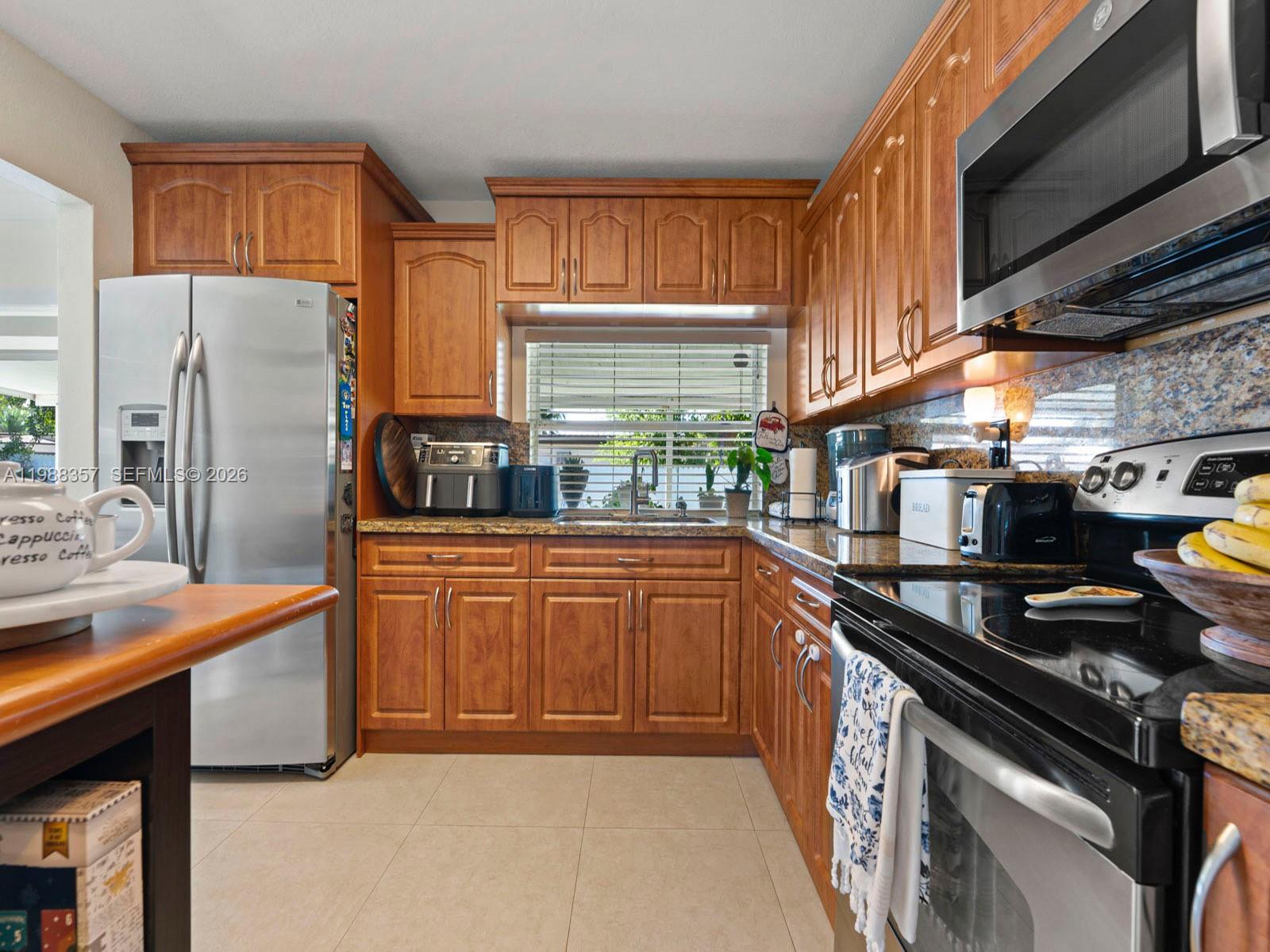 8530 Northwest 179th Street Hialeah, FL 33015 - Photo 19 of 28 a kitchen with stainless steel appliances granite countertop a sink stove and refrigerator