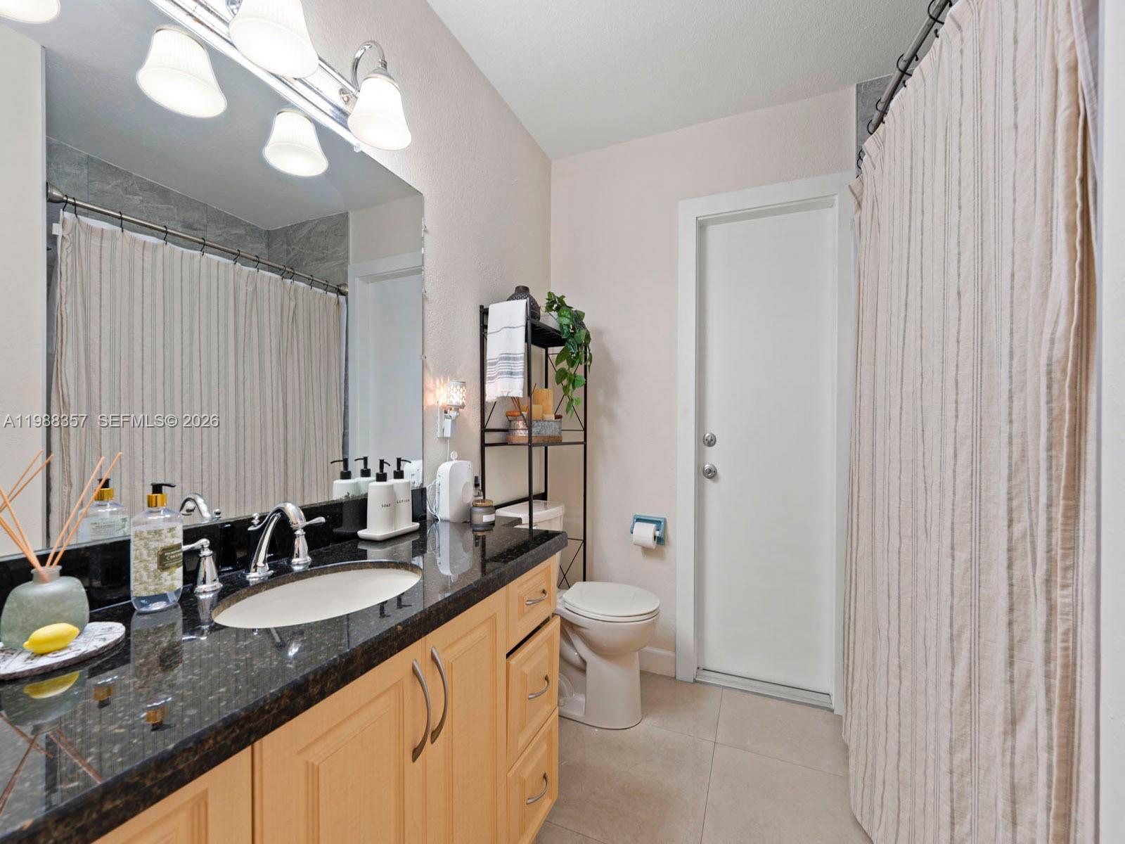 8530 Northwest 179th Street Hialeah, FL 33015 - Photo 22 of 28 a bathroom with a granite countertop double vanity sink a mirror and a shower