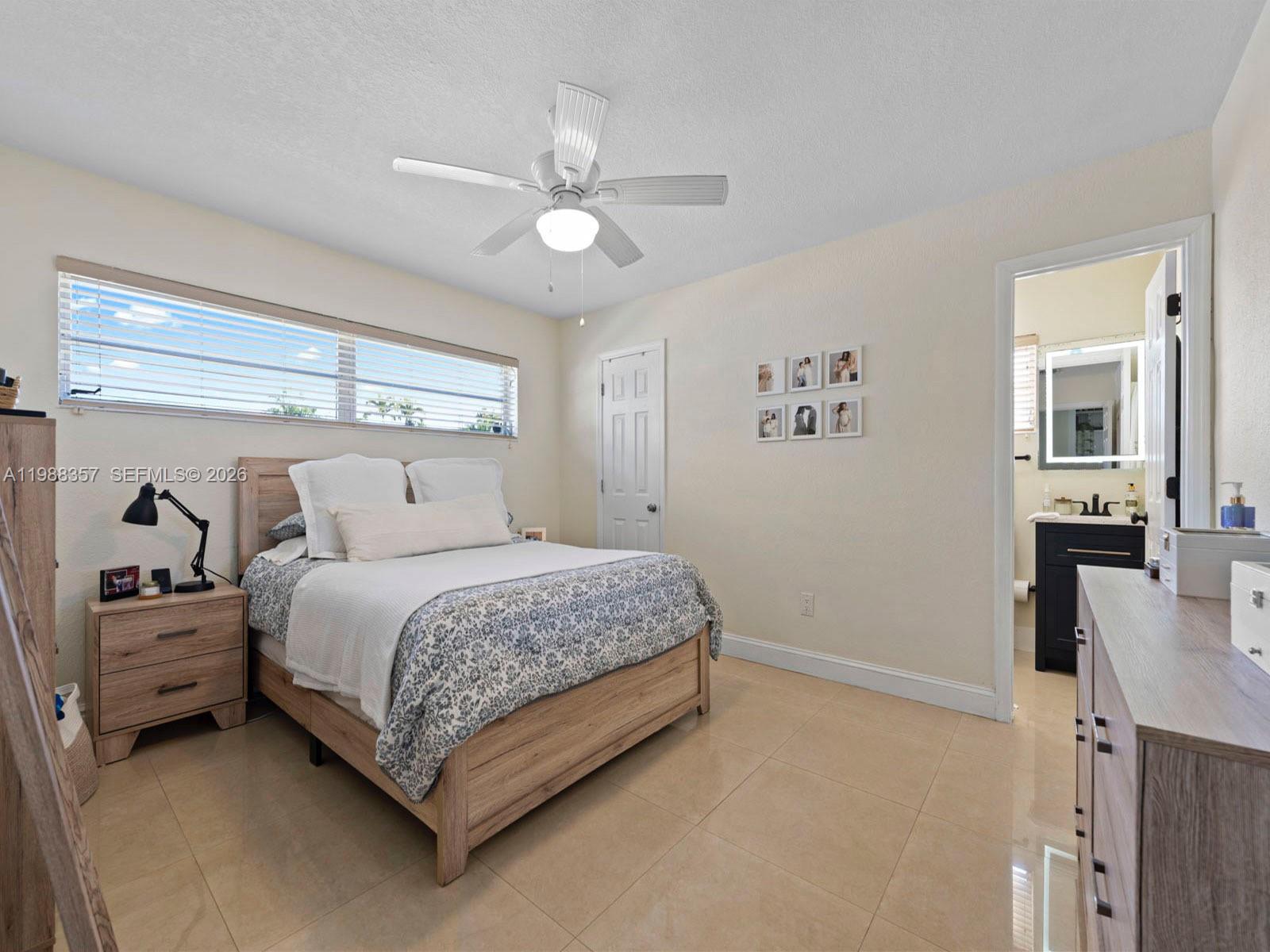 8530 Northwest 179th Street Hialeah, FL 33015 - Photo 5 of 28 a bedroom with a bed and a chandelier
