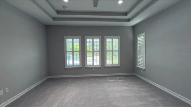 an empty room with a window and ceiling fan