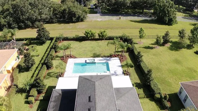 an aerial view of a house with yard swimming pool and outdoor seating