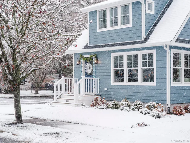 a view of a brick house with a large tree