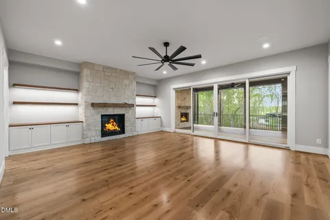 an empty room with fireplace and wooden floor