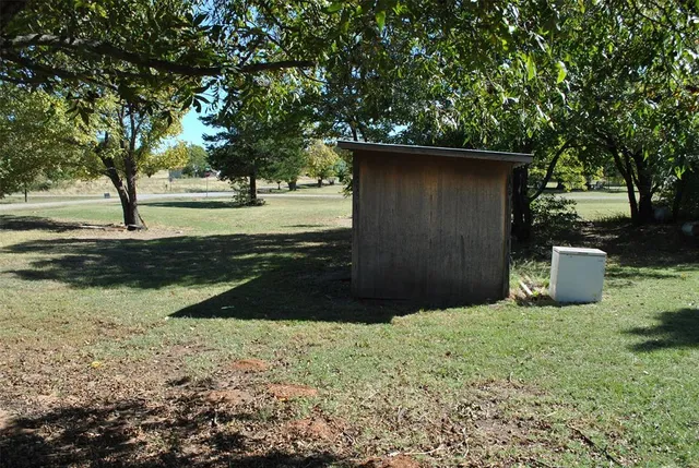 a view of backyard of house with trees