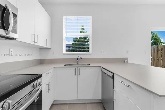 a kitchen with a sink cabinets and window