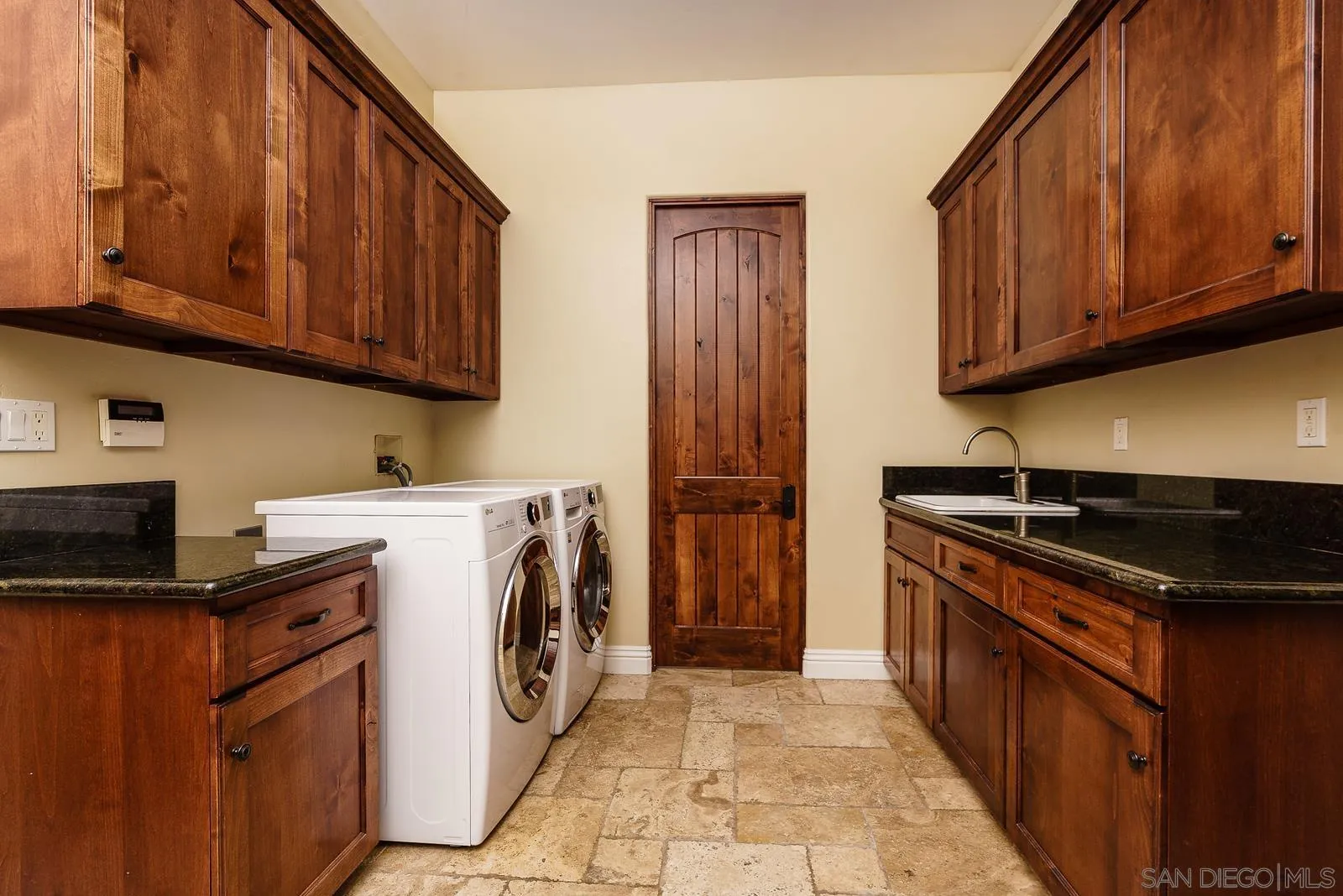 31781 Wrightwood Road Bonsall, CA 92003 - Photo 31 of 46 a utility room with granite countertop a stove top oven a sink dishwasher and cabinets with wooden floor