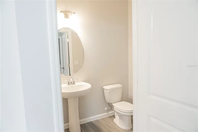 a bathroom with a toilet a sink and a mirror