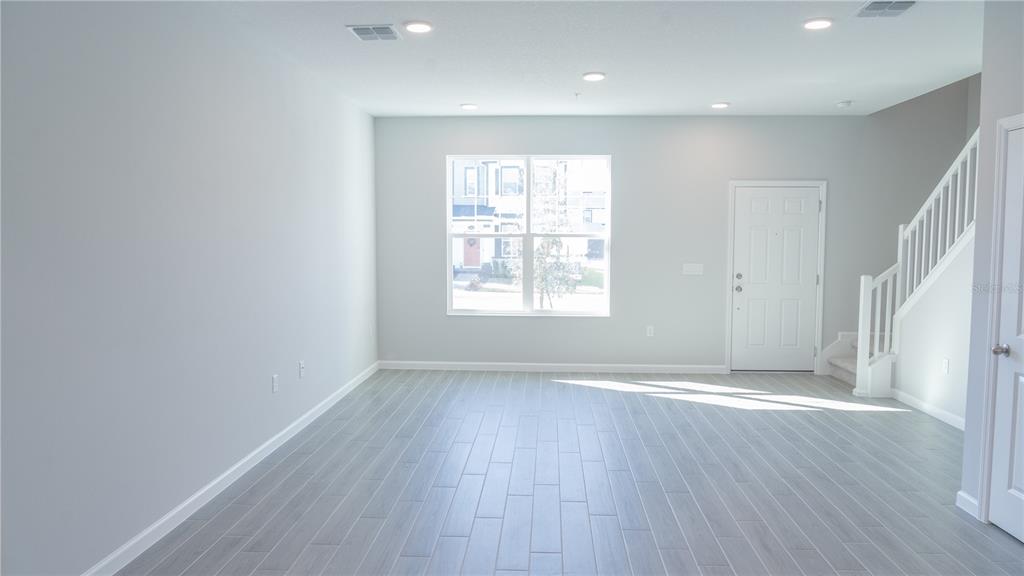 583 Pothos Street Apopka, FL 32703 - Photo 7 of 26 an empty room with wooden floor and windows