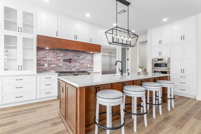 a kitchen with granite countertop a table chairs stove and wooden floor