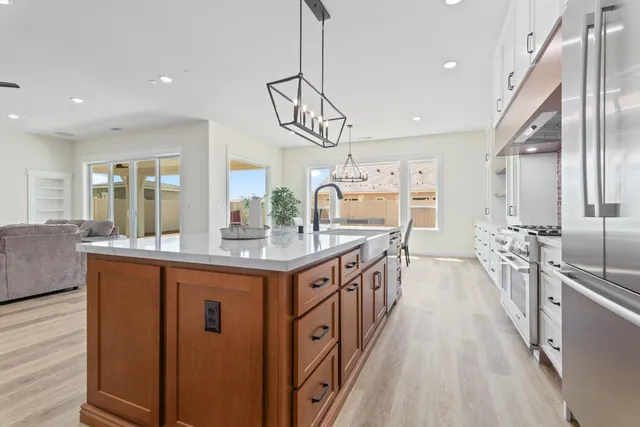 a kitchen with stainless steel appliances granite countertop a lot of counter space and wooden floors